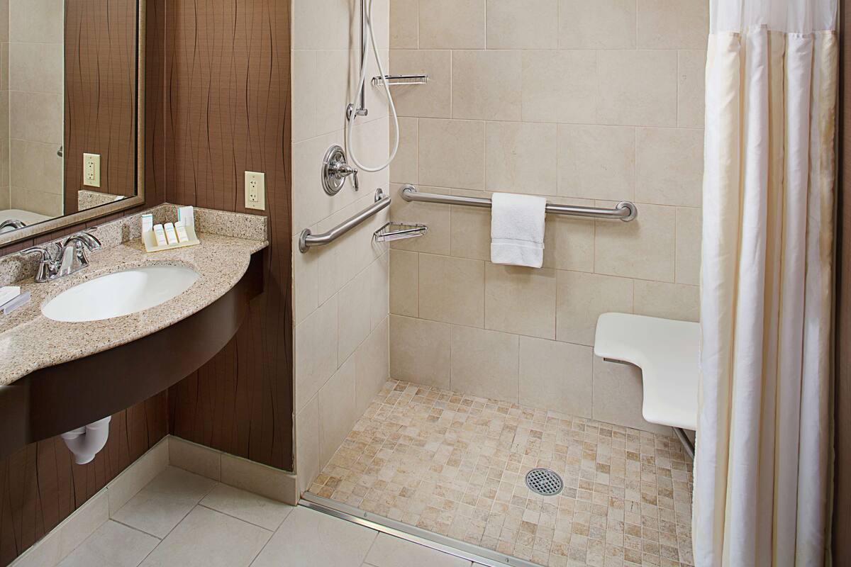 Une salle de bain moderne équipée d’une douche, d’un lavabo et de toilettes.