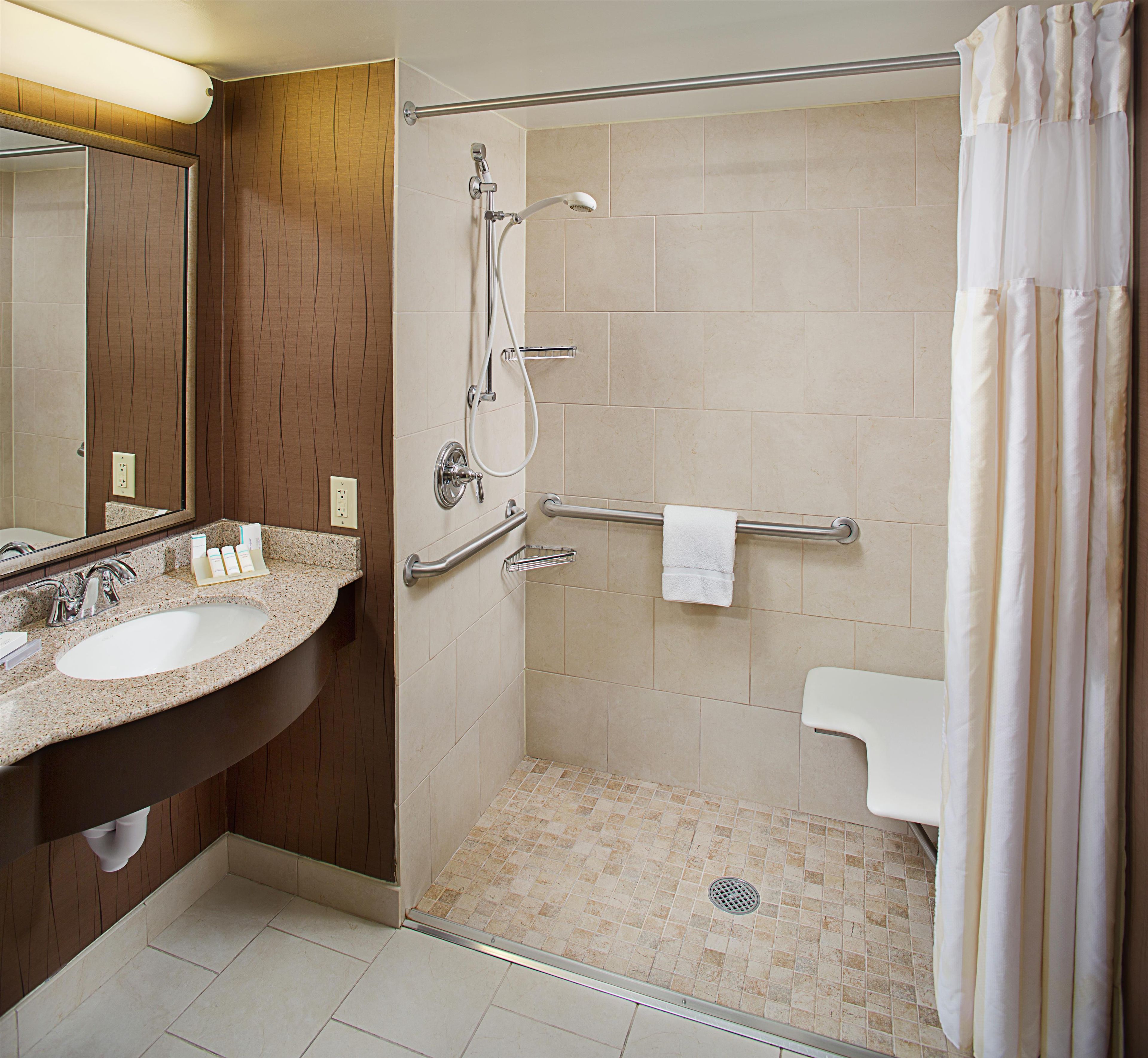A bathroom with a shower, a sink, and a toilet.