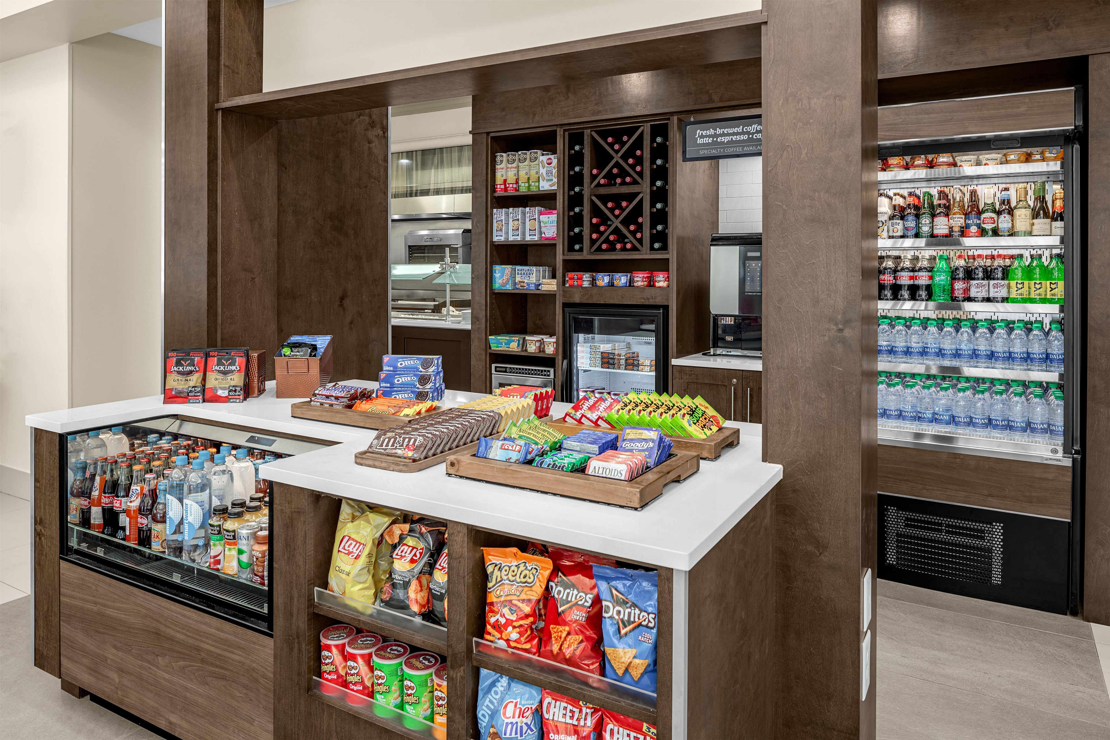 A snack bar with a variety of snacks, beverages, and a coffee machine.