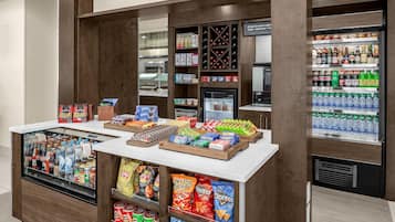 A snack bar with a variety of snacks, beverages, and a coffee machine.