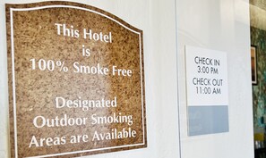 A sign indicating the hotel is 100% smoke-free with designated outdoor smoking areas.