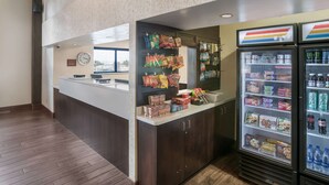 A self-service kiosk with snacks and beverages, a clock, and a view of the outside.
