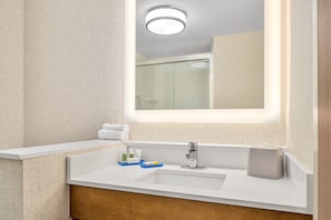 A modern bathroom with a large mirror, a white sink, and a glass shower enclosure. - Holiday Inn Express Ft. Lauderdale Cruise-Airport by IHG (Fort Lauderdale)