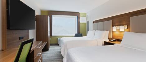 A hotel room with two beds, a desk, a chair, a TV, and a window with a city view.