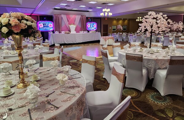 A banquet hall with round tables set for a formal event, featuring white tablecloths and gold accents. - Holiday Inn & Suites Bolingbrook by IHG (Bolingbrook)