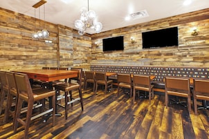 Un restaurante con un diseño de pared de madera, diversas disposiciones de asientos y un televisor de pantalla plana montado en la pared.