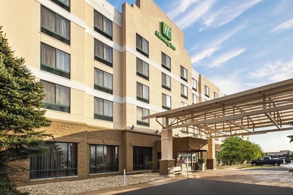 Un hotel con entrada cubierta, varias ventanas y un letrero que indica que es un Holiday Inn.
