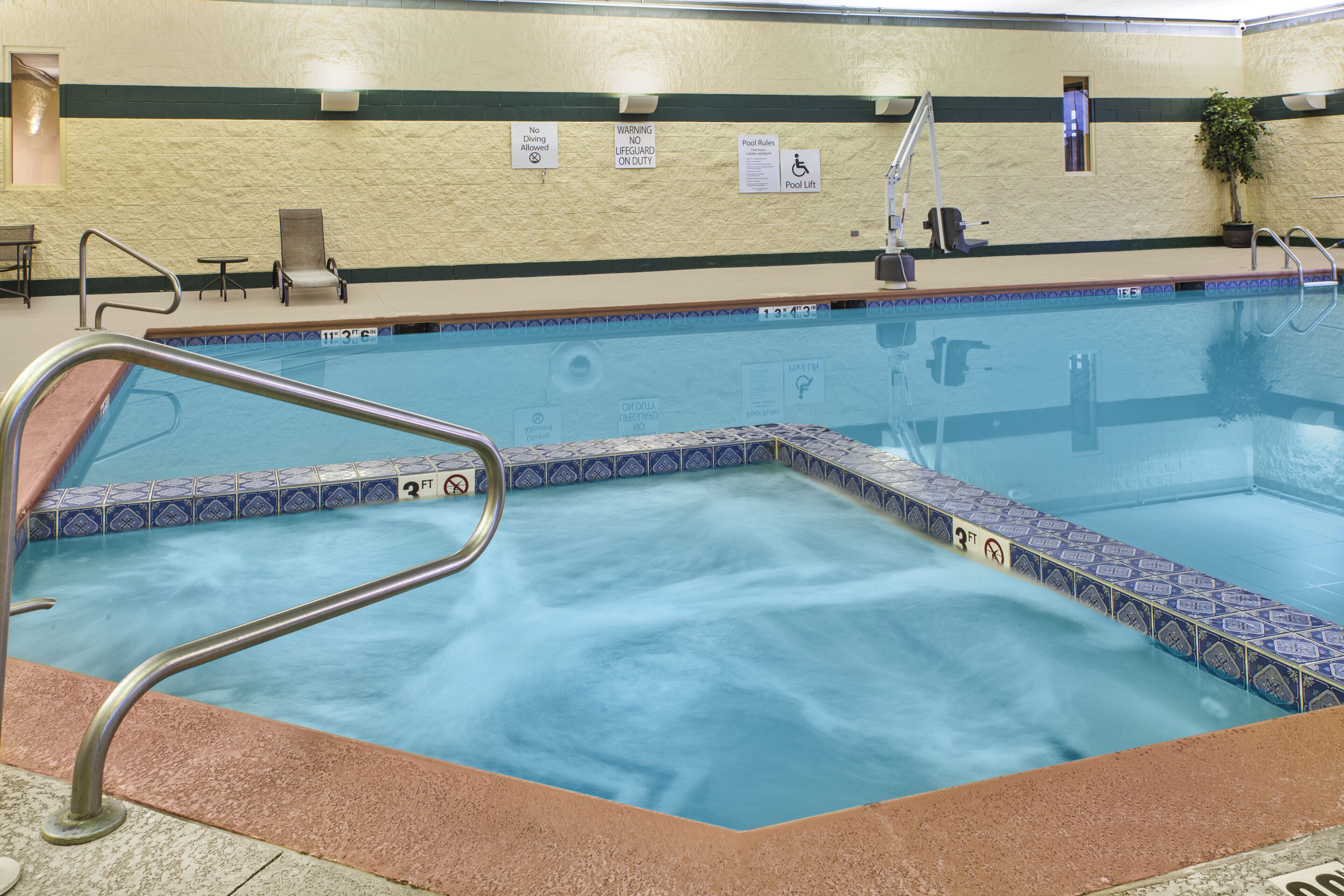 Una piscina techada, sillones reclinables de piscina