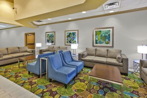 A hotel lobby with multiple seating areas, including sofas and armchairs, and a patterned carpet. - Holiday Inn & Suites Bolingbrook by IHG (Bolingbrook)