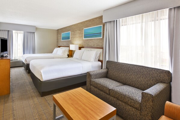 A hotel room with two beds, a sofa, a TV, and a desk. - Holiday Inn & Suites Bolingbrook by IHG (Bolingbrook)