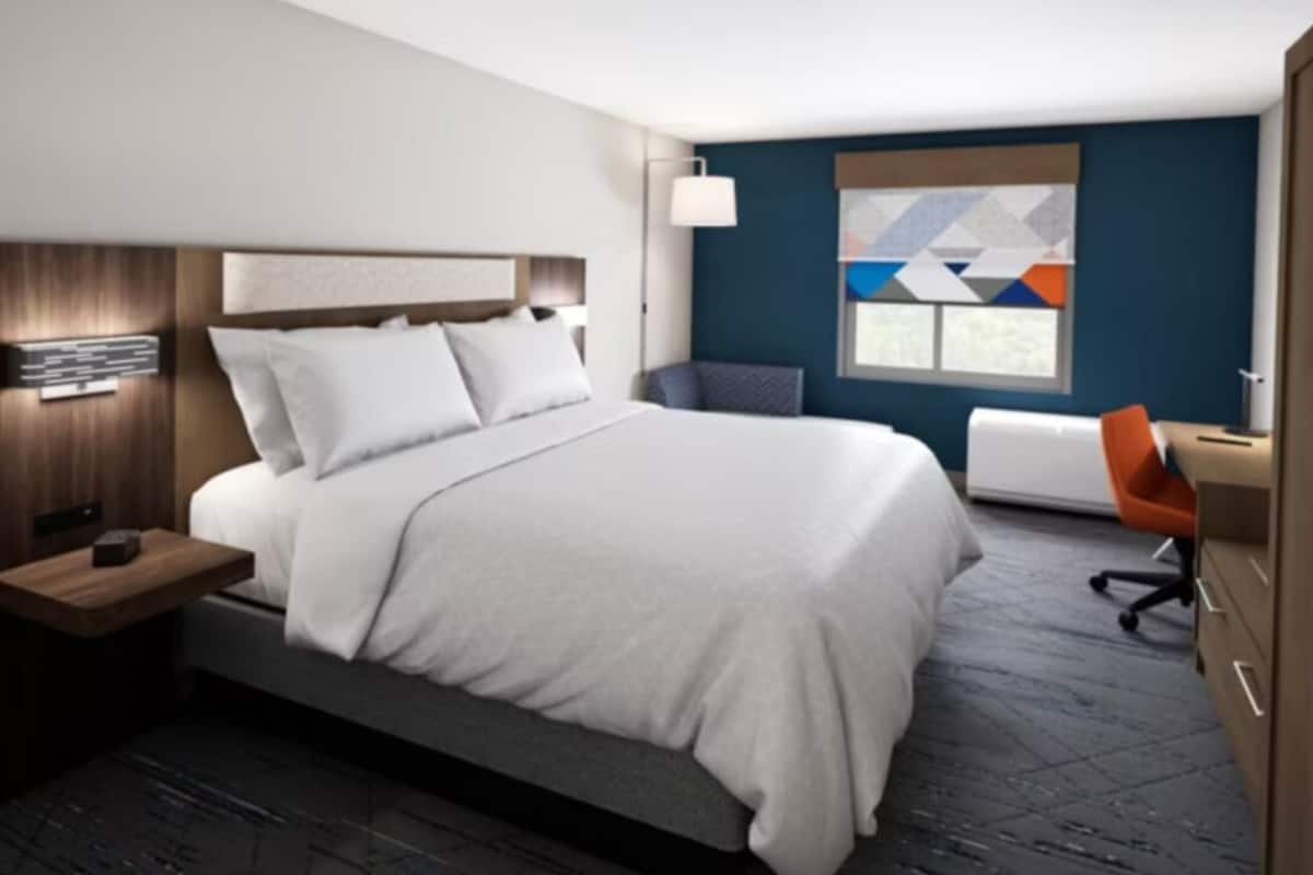 Une chambre d’hôtel moderne avec un grand lit, un bureau et une chaise.
