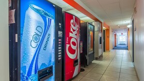Un couloir où se trouvent des distributeurs automatiques proposant des boissons fraîches et du Coca-Cola.