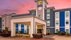A Comfort Inn hotel with a modern design, featuring a prominent 'Comfort' sign, a covered entrance, and a star logo. - Comfort Inn & Suites Houston FM1960 - Champions (Houston)