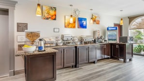 A modern kitchen with a breakfast bar, coffee maker, microwave, and a refrigerator. - Comfort Inn & Suites Houston FM1960 - Champions (Houston)