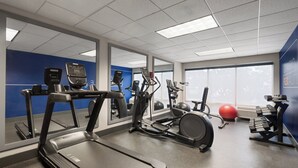 A gym with treadmills, elliptical machines, and free weights.