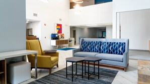 A modern living room with a sofa, armchair, coffee table, and a small table. - Holiday Inn Express & Suites Hiawassee by IHG (Hiawassee)