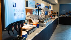 A breakfast bar with a coffee machine labeled "SQUEEZE THE DAY" and various food options. - Holiday Inn Express & Suites Hiawassee by IHG (Hiawassee)