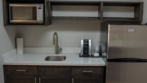A kitchen with a built-in microwave, a coffee maker, a stainless steel sink, and a refrigerator. - Holiday Inn Express Hotel & Suites Conover (Hickory Area) by IHG (Conover)