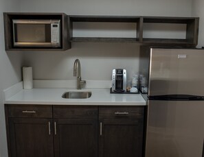 A kitchen with a built-in microwave, a coffee maker, a stainless steel sink, and a refrigerator. - Holiday Inn Express Hotel & Suites Conover (Hickory Area) by IHG (Conover)