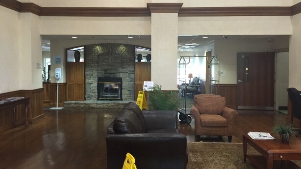 A spacious lobby with a stone fireplace, wooden furniture, and a high ceiling. - Holiday Inn Express Hotel & Suites Conover (Hickory Area) by IHG (Conover)