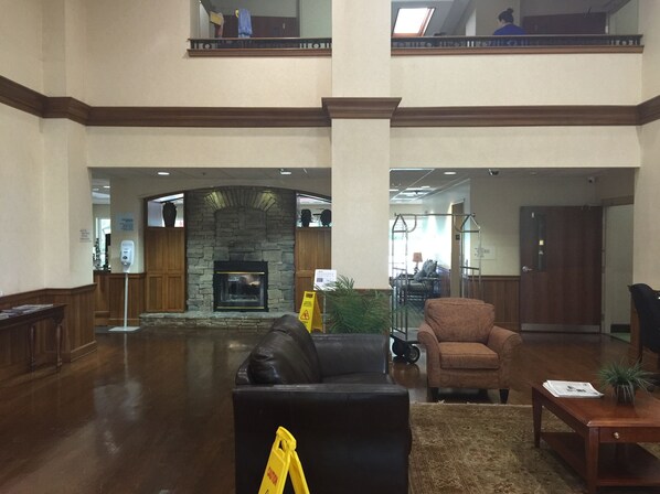 A spacious lobby with a stone fireplace, wooden furniture, and a high ceiling. - Holiday Inn Express Hotel & Suites Conover (Hickory Area) by IHG (Conover)
