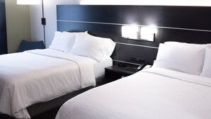 A hotel room with two beds, a nightstand, and a wall-mounted light fixture. - Holiday Inn Express Hotel & Suites Conover (Hickory Area) by IHG (Conover)