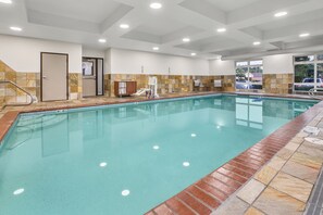 A swimming pool with a tiled border, a changing room, and a door. - Holiday Inn Express & Suites Tacoma by IHG (Tacoma)