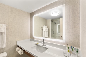 A modern bathroom with a large mirror, white sink, and a toilet. - Holiday Inn Express & Suites Tacoma by IHG (Tacoma)