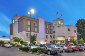 A Holiday Inn Express hotel with a parking lot full of cars. - Holiday Inn Express & Suites Tacoma by IHG (Tacoma)