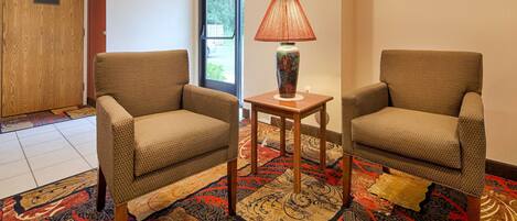 A meeting room with two chairs, a table, and a lamp.