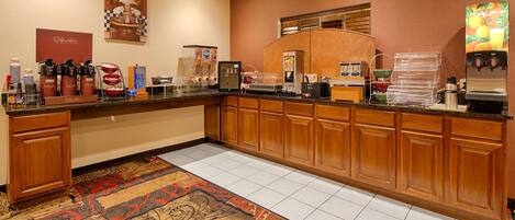 A hotel kitchen with a coffee station, a microwave, and a refrigerator.