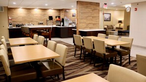 A hotel lobby with multiple tables and chairs, a reception desk, and a coffee station. - Best Western Fostoria Inn & Suites (Fostoria)