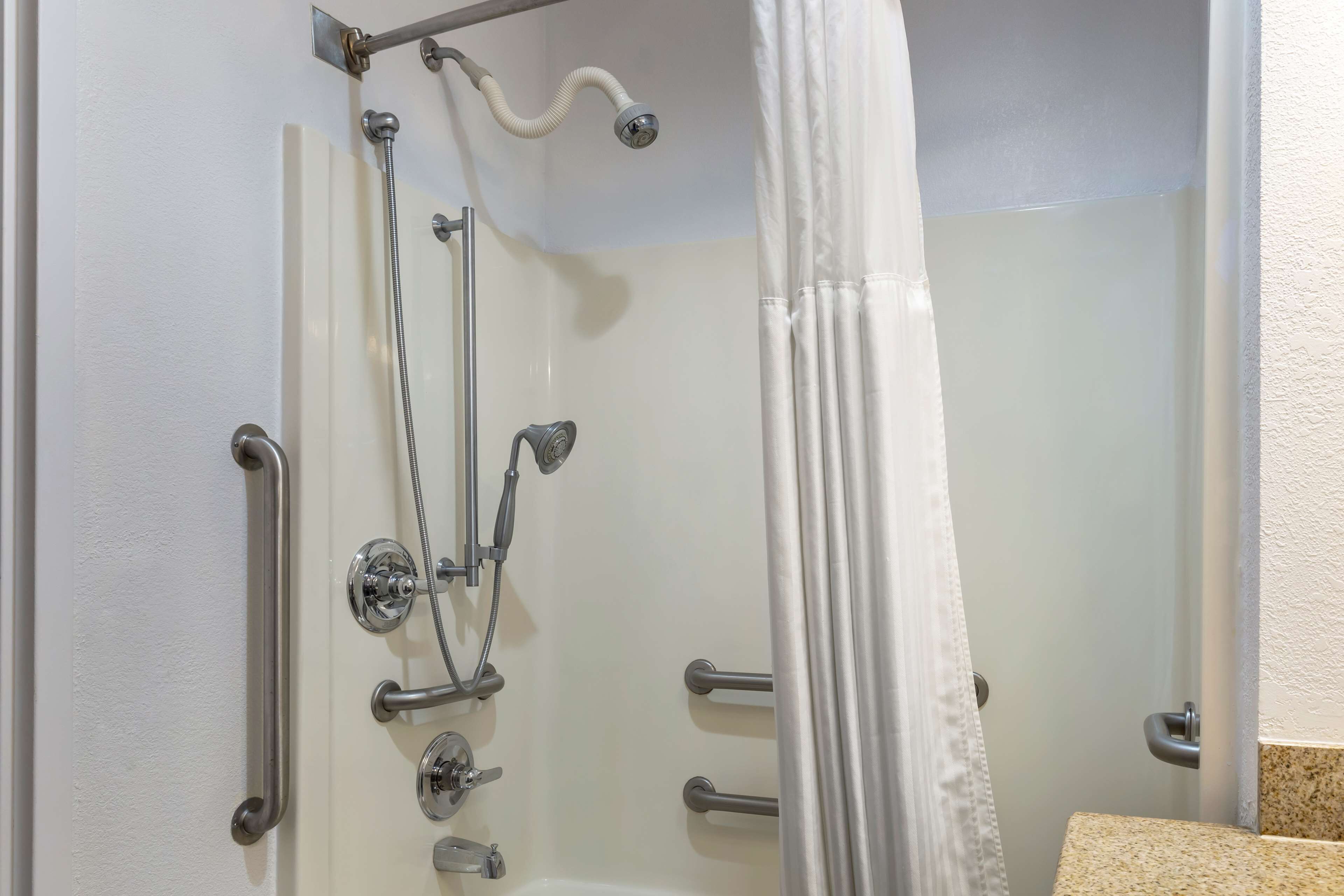 Eine Dusche mit Duschbrause, Handbrause und Reinigungsbürste.