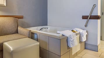 Un bagno con una vasca, un portasciugamani e una barra di sostegno.
