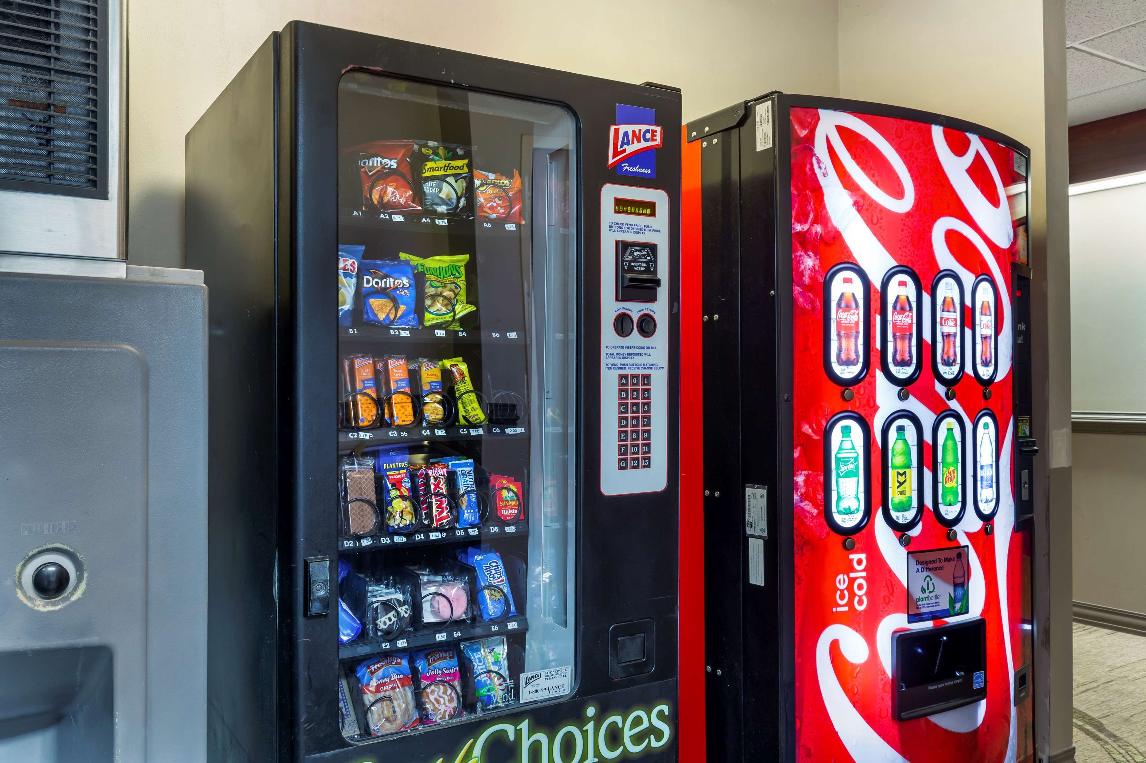 Un distributeur automatique proposant une variété de collations et de boissons, notamment des Doritos et des Smartfood.
