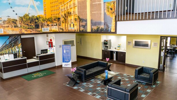 Un hall de hotel con mostrador de recepción, zona de estar y kitchenette.