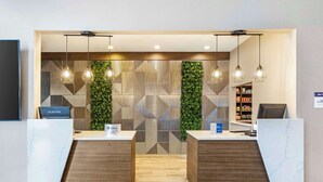 A reception area with marble counters, hanging pendant lights, a geometric patterned wall, and a green vertical garden. - Best Western Plus Bourbonnais Hotel & Suites (Bourbonnais)