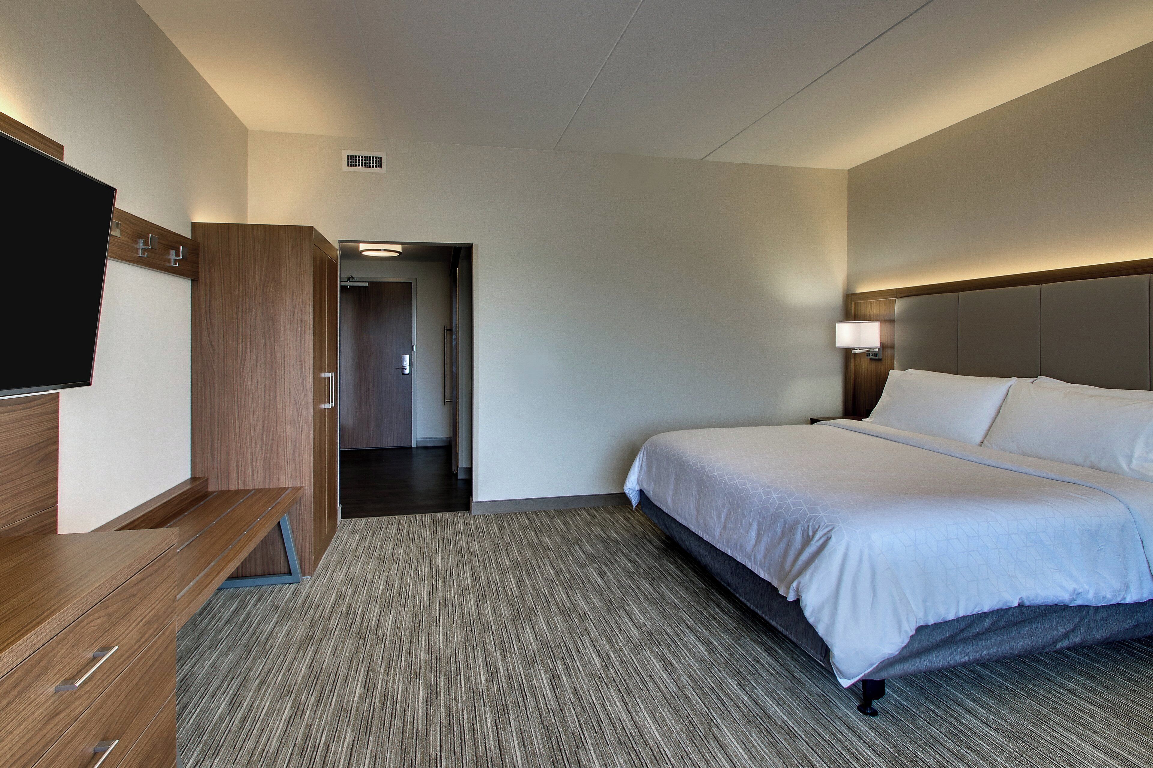 Ein Hotelzimmer mit Bett, Nachttisch und Fernseher.