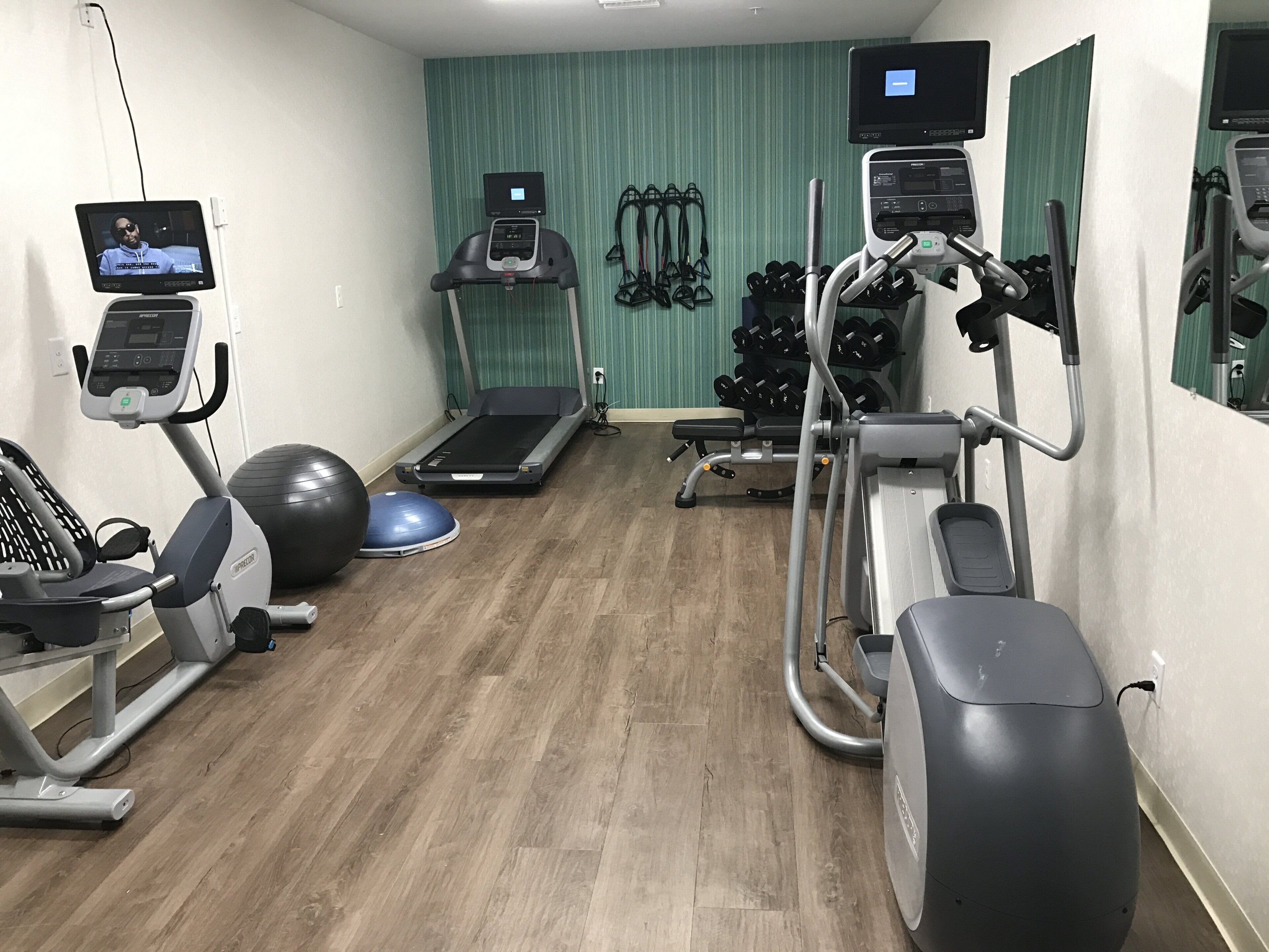 Un centre de remise en forme équipé de tapis de course, de vélos elliptiques et d’une variété d’appareils de musculation.