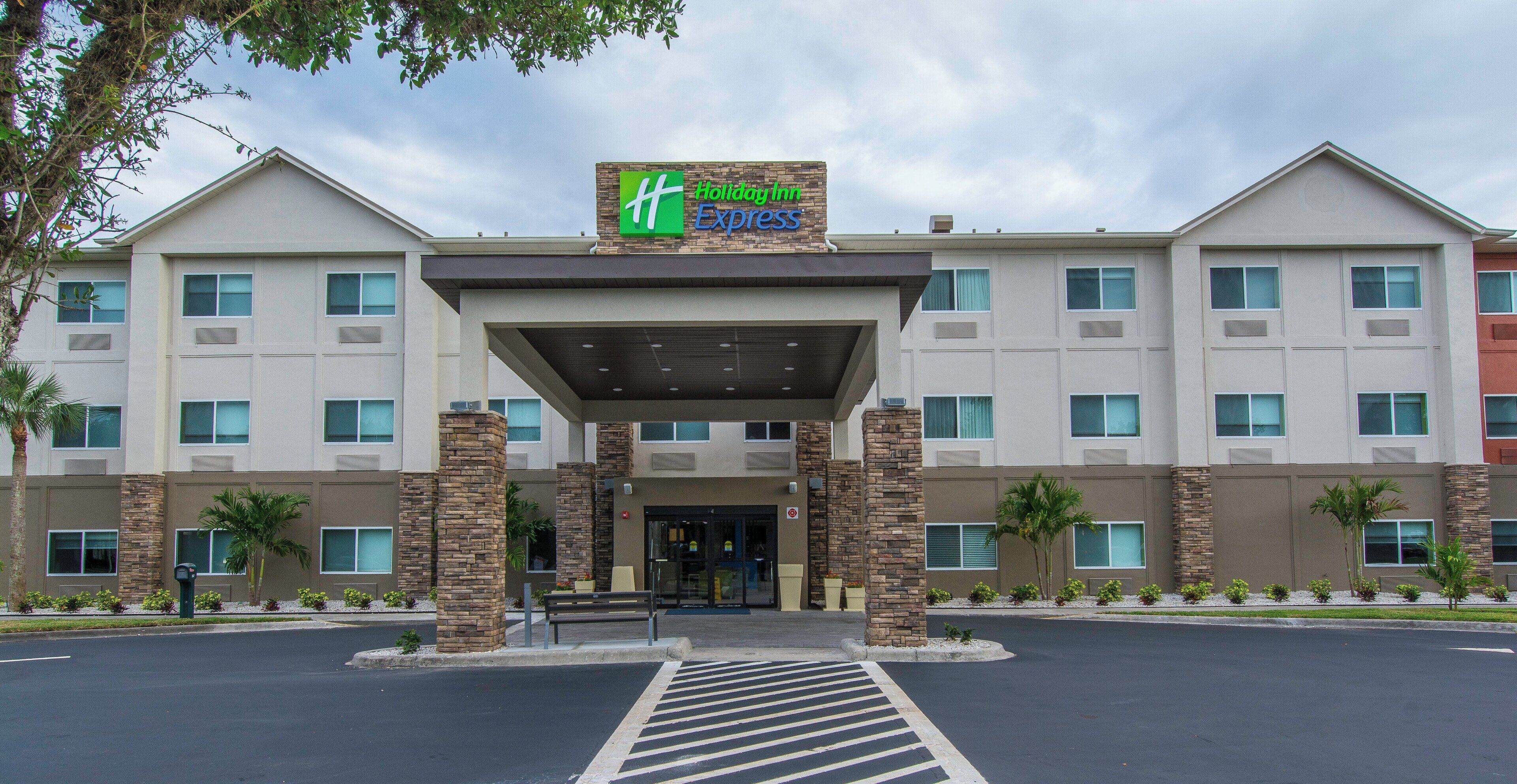A Holiday Inn Express hotel with a covered entrance, multiple windows, and a parking lot.