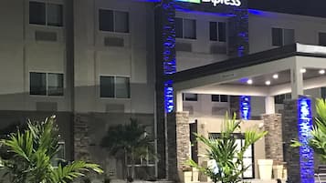 A Holiday Inn Express building with a modern facade, a covered entrance, and a well-lit exterior.