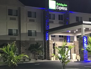 A Holiday Inn Express building with a modern facade, a covered entrance, and a well-lit exterior. - Holiday Inn Express Naples South I-75 by IHG (Naples)