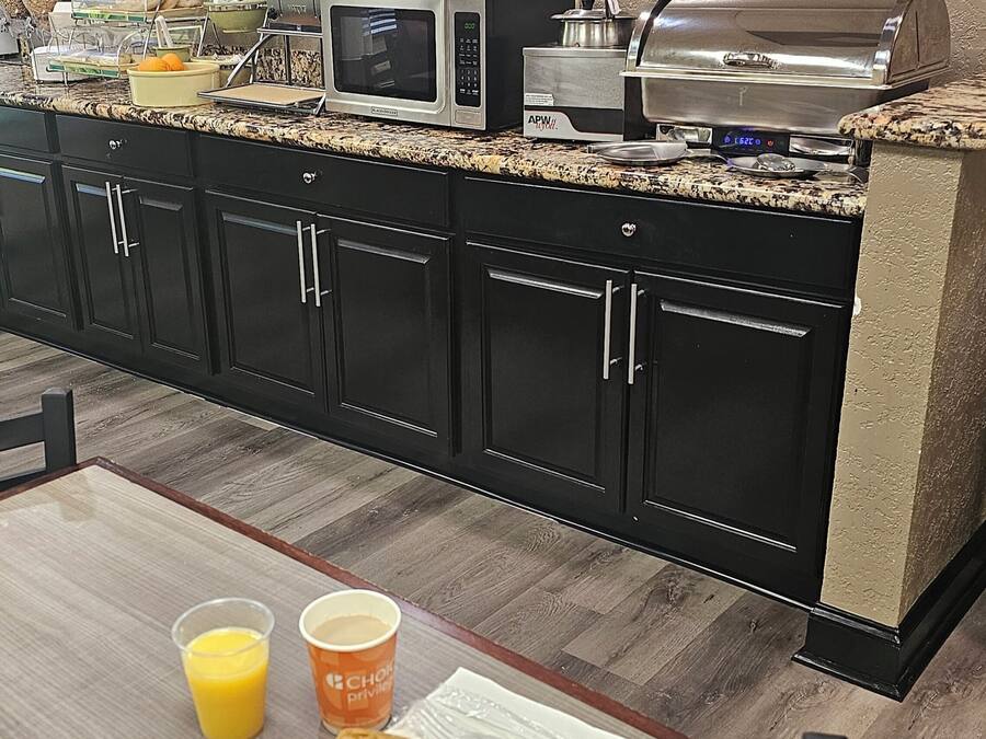 A breakfast buffet setup with a microwave, toaster, and coffee maker.