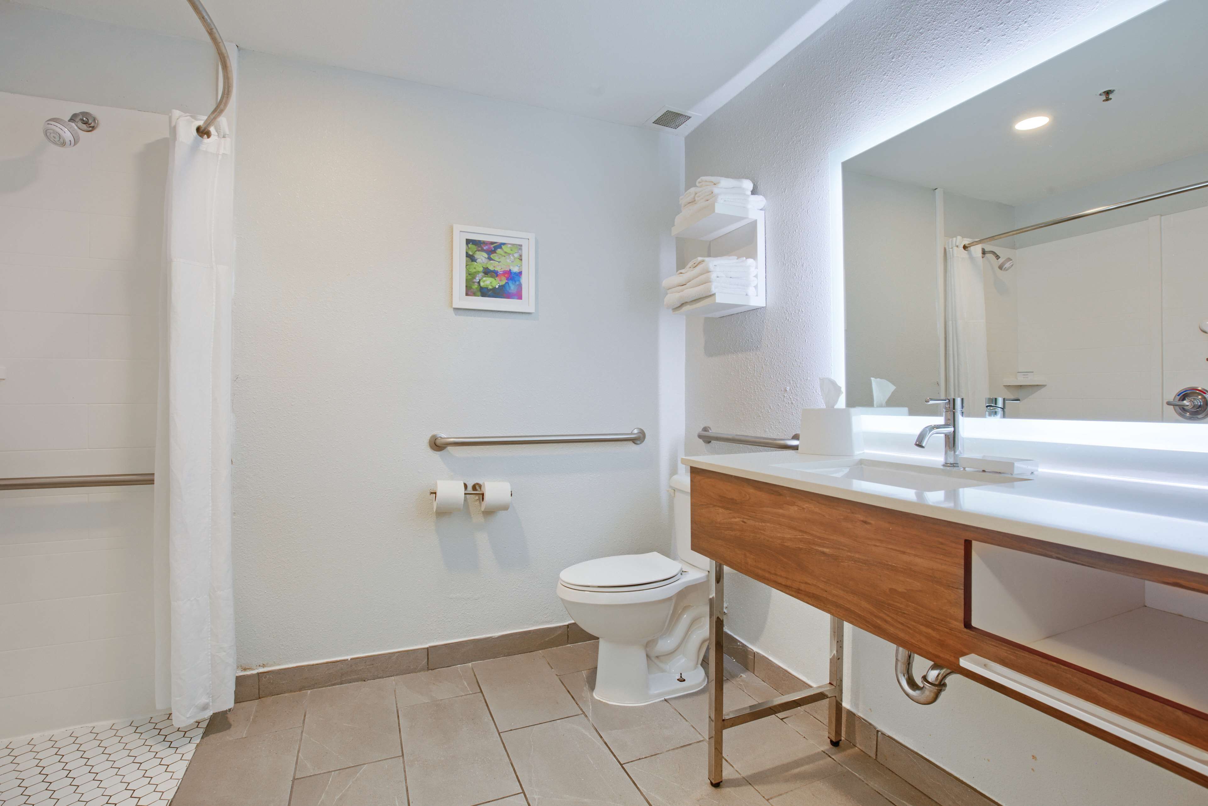 Un baño moderno con ducha, inodoro y tocador.