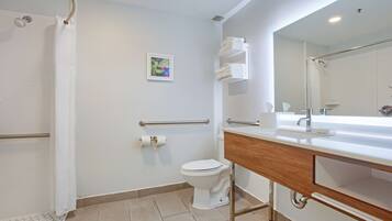 Un baño moderno con ducha, inodoro y tocador.