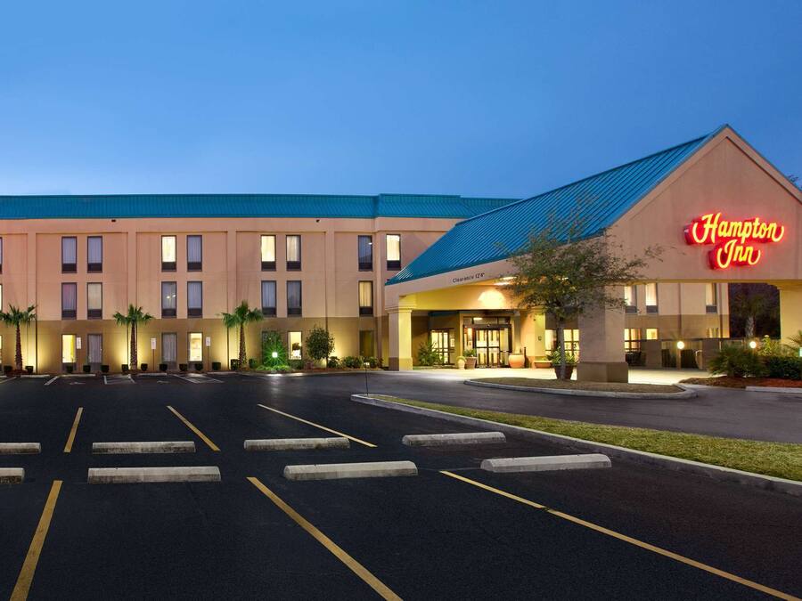 Un hotel Hampton Inn con un estacionamiento amplio y una entrada bien iluminada.