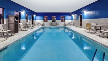 Relax by the pool surrounded by lounge chairs and tables.