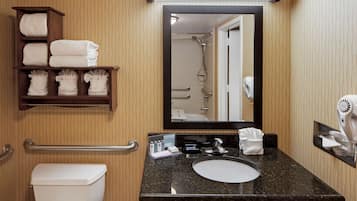 A bathroom with a toilet, sink, towel rack, and a mirror.