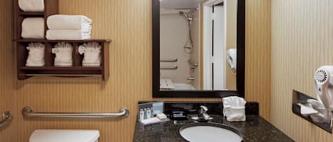 A bathroom with a toilet, sink, towel rack, and a mirror.