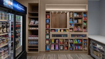 A commercial refrigeration unit with shelves stocked with beverages and snacks.